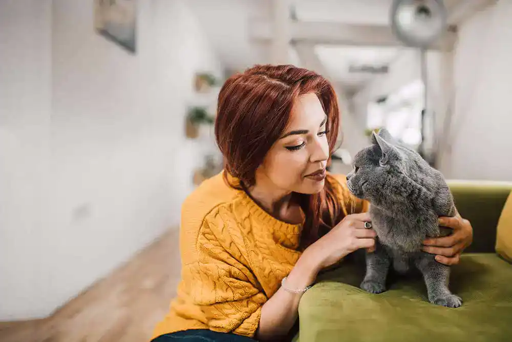 A dark-haired woman with her grey cat